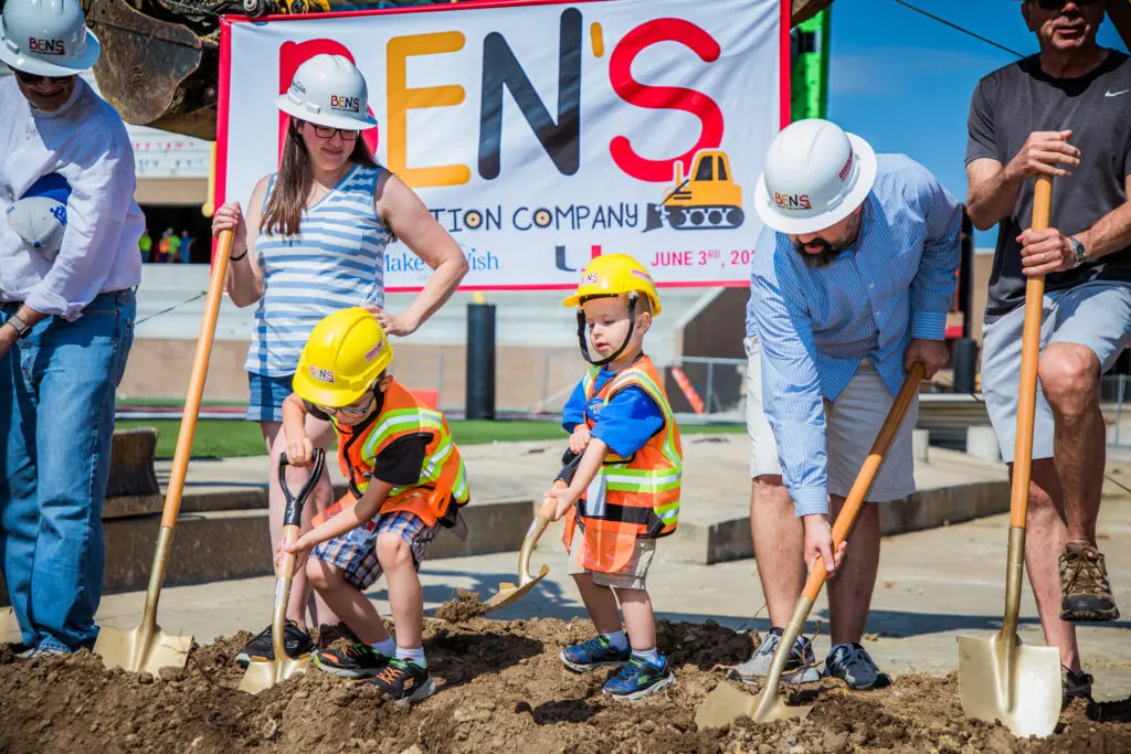 A group of people with shovels at a construction site.