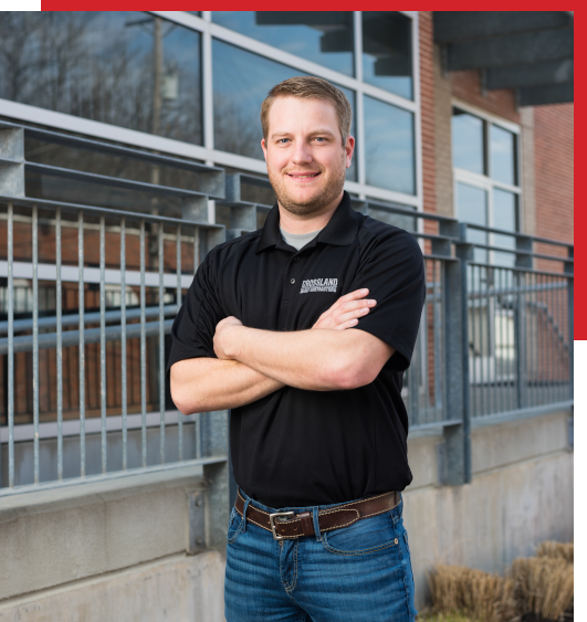 A man with his arms crossed in front of a building.