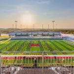 A view of a football field with a stadium in the background.