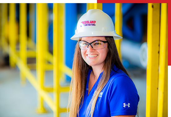 Crossland Construction employee wearing hardhat in warehouse.