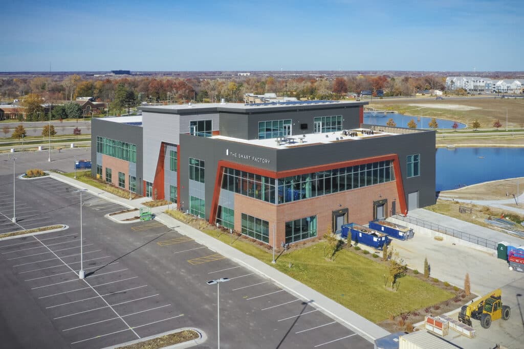 Aerial view of The Smart Factory, a three-story office building beside a pond